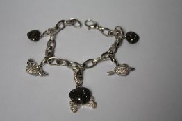 A THEO FENNELL OF LONDON 18CT WHITE GOLD AND DIAMOND BRACELET WITH FIVE ASSORTED JEWELLED CHARMS,