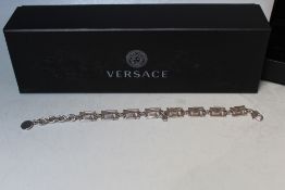 A BOXED VERSACE SILVER TONE BRACELET, Greek key design with Medusa charm, lobster clap, overall L 25