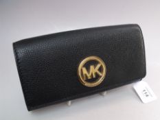 A MICHAEL KORS BLACK GRAINED LEATHER LADIES WALLET / PURSE, with gold tone circular logo to front