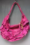 A CHRISTIAN DIOR PINK LEATHER BOHO STYLE HANDBAG, with frilled detail, zip fastening, red satin