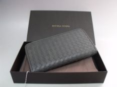A BOTTEGA VENETA LADIES 'BASKET WEAVE' EFFECT GREEN LEATHER PURSE, all around zip closure, with dust