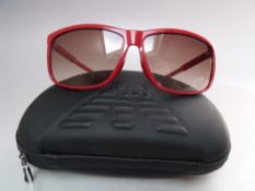 A PAIR OF MENS EMPORIO ARMANI SUNGLASSES IN RED, with embossed case and cleaning cloth