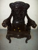AN EBONITED CARVED ORIENTAL STYLE CHAIR.
