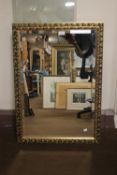 A GILT FRAMED MIRROR, 82 X 58 CM