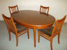 A TEAK EXTENDING OVAL DINING SET WITH FOUR CHAIRS