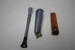 A GOLD AND AMBER CIGARETTE HOLDER, A SILVER CIGARETTE HOLDER AND A SILVER CASE