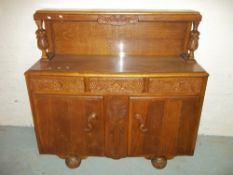 AN OAK MID CENTURY SIDEBOARD WITH CARVED DETAIL