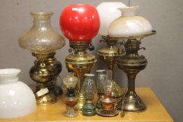 A COLLECTION OF OIL LAMPS TOGETHER WITH THREE PICTURE FRAMES