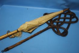 A CARPET BEATER AND A VINTAGE PARASOL