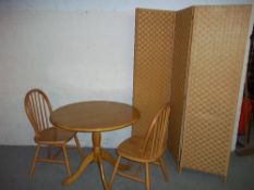 A ROUND DINING SET INCLUDING A TABLE TWO CHAIRS AND A PRIVACY SCREEN.