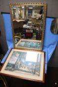 A GILT FRAMED MIRROR, 98 X 67 CM TOGETHER WITH A FRAMED AND GLAZED PRINT OF A STREET SCENE