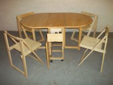 A MODERN DROPLEAF STORE AWAY DINING SET WITH FOUR FOLDING CHAIRS.