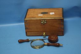 A WOODEN BOX CONTAINING A LETTER OPENER, MAGNIFYING GLASS AND A TAPE MEASURE
