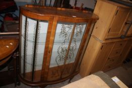 A WALNUT BOWED CHINA CABINET.