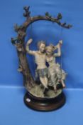 A CAPO DE MONTE FIGURE GROUP - A BOY AND A GIRL ON A SWING