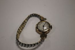 A VINTAGE LADIES 9 CT GOLD CASED WRIST WATCH ON A PLATED EXPANDING STRAP