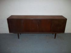 A VINTAGE TEAK SIDEBOARD WITH SLIDING DOORS.