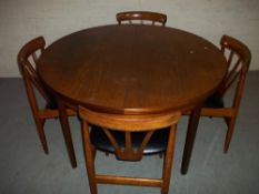 A TEAK EXTENDING TABLE AND FOUR CHAIRS.