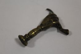 A VINTAGE BRASS PIPE TAMPER IN THE FORM OF A HAND