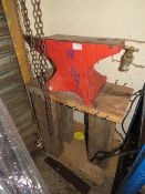 A VINTAGE RED ANVIL ON WOODEN STAND