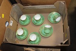 A SET OF SIX GREEN AND GILT ROYAL DOULTON COFFEE CUPS AND SAUCERS