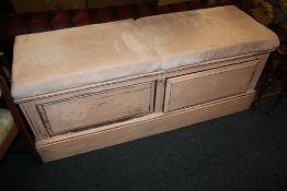 AN UPHOLSTERED PAINTED OTTOMAN WITH DRAWERS