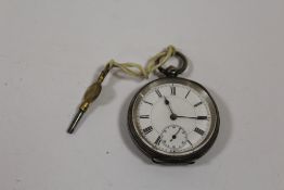 A SMALL ANTIQUE SILVER POCKET WATCH WITH KEY