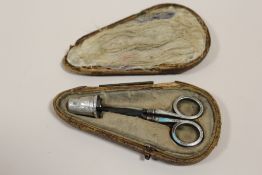 AN ANTIQUE SILVER THIMBLE AND SCISSORS SET IN FITTED CASE