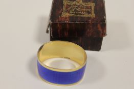 A HALLMARKED SILVER GILT AND ENAMEL NAPKIN RING