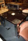 A MODERN BLACK GLASS DINING TABLE 102 X 102 cm