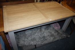 A MODERN OAK EFFECT EXTENDING DINING TABLE