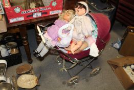 A VINTAGE DOLLS PRAM CONTAINING DOLLS
