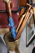 A BRASS STICK STAND CONTAINING VINTAGE WALKING STICKS, ETC.