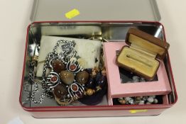 A TIN OF COSTUME JEWELLERY TO INCLUDE A LARGE DAVID GRAU PENDANT ON CHAIN, TIE PIN ETC.