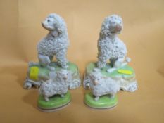 A PAIR OF DRESDEN CERAMIC DOG FIGURES TOGETHER WITH A SMALLER PAIR OF DRESDEN SHEEP FIGURES (4)