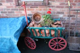 A VINTAGE PAINTED WOODEN CART CONTAINING A LARGE QUANTITY OF PLANT POTS