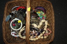 A WICKER BASKET OF COSTUME JEWELLERY