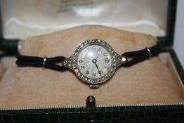 A LADIES VINTAGE PLATINUM AND DIAMOND SET WATCH - EACH BRILLIANT CUT DIAMOND APPROX 0.02 CARATS -