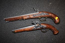 A REPRODUCTION DOUBLE BARREL DECORATIVE FLINT LOCK PISTOL TOGETHER WITH A SINGLE BARREL EXAMPLE