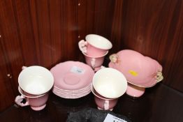 A SET OF SIX FLORAL HANDLED ROYAL WINTON CUPS AND SAUCERS, TOGETHER WITH A SIMILAR COMPORT