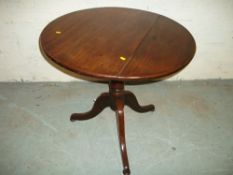 A GEORGIAN STYLE ROUND TILT TOP TABLE IN MAHOGANY.