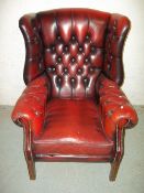 A RED OXBLOOD LEATHER DEEP BUTTONED WING BACK CHESTERFIELD STYLE CHAIR