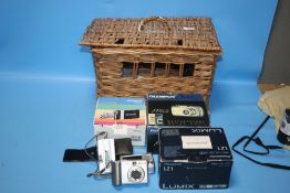 A WICKER BASKET CONTAINING CAMERAS, A POLOROID PRINTER ETC.