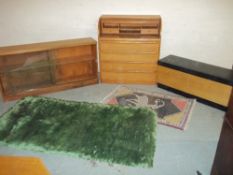 A ROLLER SHUTTER TEAK BUREAU, A VINTAGE GLAZED LOW WIDE TEAK BOOKCASE, AND A BKANKET BOX ETC.