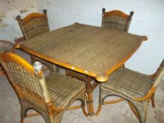 A WICKER DINING TABLE AND FOUR CHAIRS