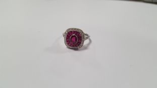 A PLATINUM RING SET WITH CENTRAL RUBY A HALO OF CALIBRE-CUT RUBIES AND A HALO OF DIAMONDS
