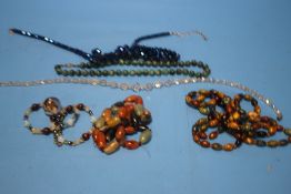 A COLLECTION OF GLASS AND HARDSTONE NECKLACES ETC.