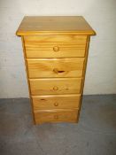A NARROW PINE CHEST OF FIVE DRAWERS