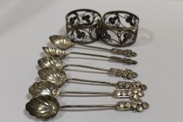 A PAIR OF UNUSUAL WHITE METAL NAPKIN RINGS, TOGETHER WITH A SET OF SIX SIMILAR COFFEE SPOONS