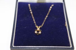 A 9CT GOLD FLORAL PENDANT ON CHAIN